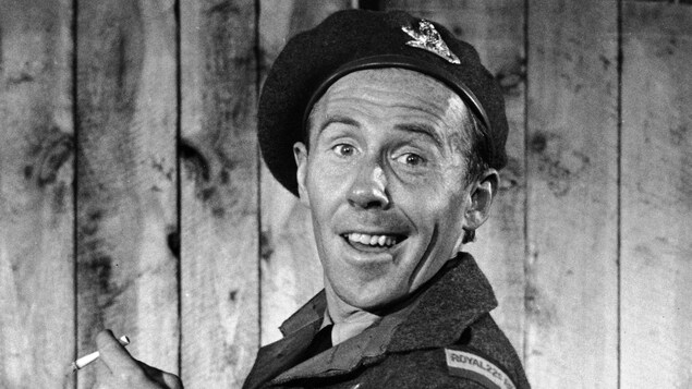 Dans son uniforme de soldat du Royal 22e Régiment, Tit-Coq (Gratien Gélinas) est tout gaillard, une cigarette à la main.