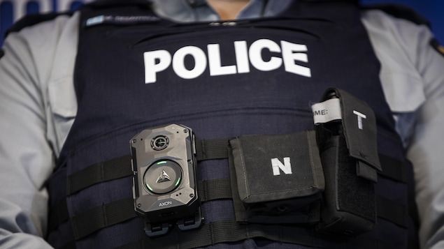 Plan rapproché d'une caméra portative Axon Body 4 attachée à des courroies autour de la veste pare-balles d'un policier.