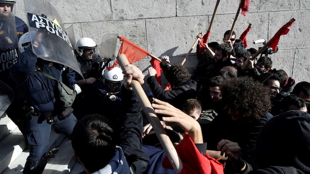 Des manifestants affrontent des policiers dans les marches du parlement d'Athènes. Des manifestants affrontent des policiers dans les marches du parlement d'Athènes.