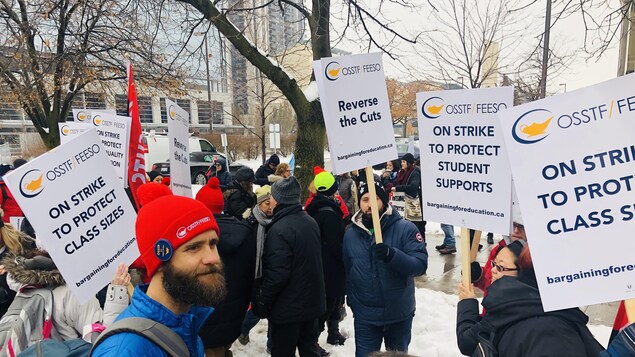 Des manifestants brandissent des pancartes dénonçant les coupes du gouvernement.