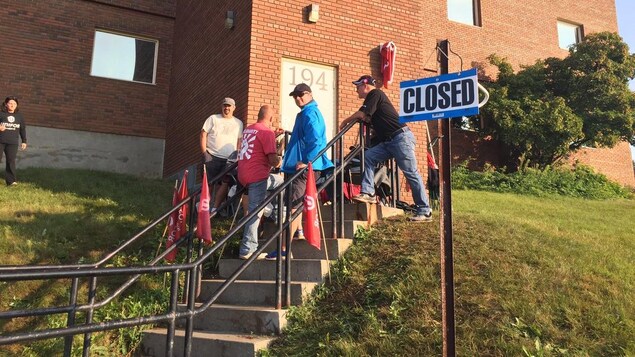 Des membres du syndicat Unifor devant la porte avec un écriteau indiquant que le centre est fermé. Des membres du syndicat Unifor devant la porte avec un écriteau indiquant que le centre est fermé.