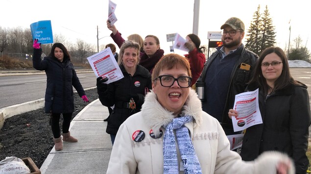 Des gens qui manifestent avec pancartes en main.