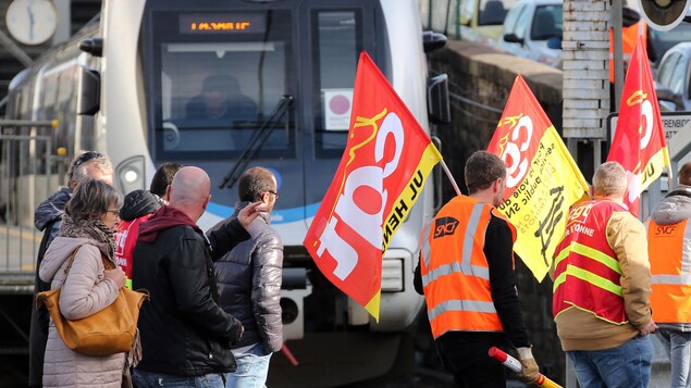 Des syndiqués passent devant un train.