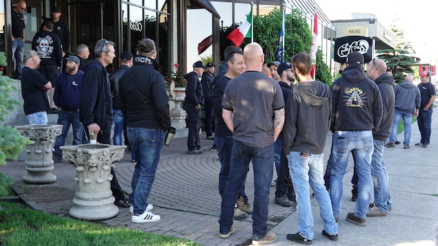 Un groupe de travailleurs se tient debout sur le trottoir. Un groupe de travailleurs se tient debout sur le trottoir.
