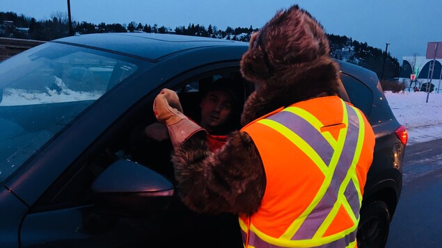 Un bénévole recueille des dons auprès d'un automobiliste. Un bénévole recueille des dons auprès d'un automobiliste.