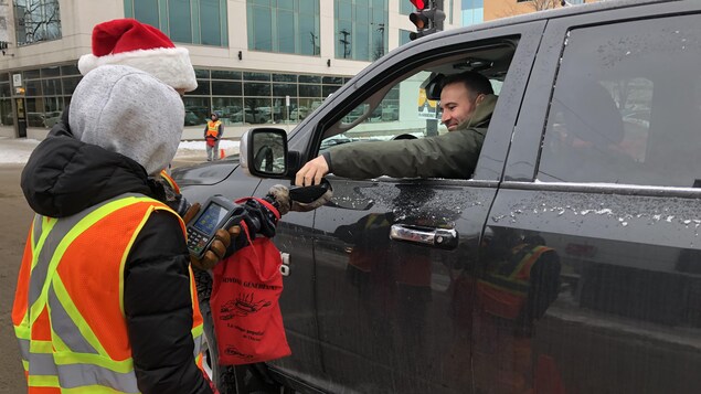 Un homme dans sa camionnette fait un don à des bénévoles.