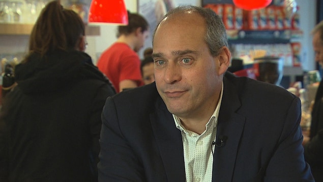 Guy Caron dans un café.