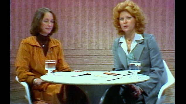 Guylaine Lanctôt assise à une table installée sur un plateau télévisé, en compagnie d'une animatrice.
