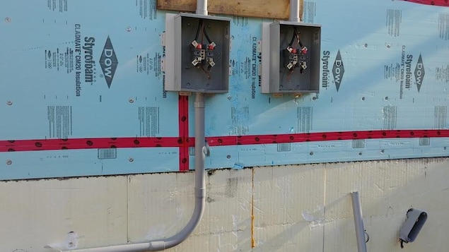 Sur un mur de maison non fini, des boîtes électriques ne contiennent plus de fils. Sur un mur de maison non fini, des boîtes électriques ne contiennent plus de fils.