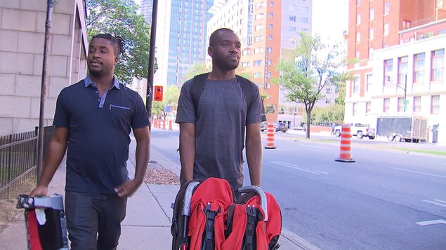 Deux hommes haïtiens marchent sur le boulevard René-Lévesque, au centre-ville de Montréal.