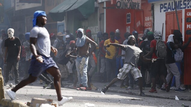 Des citoyens lancent des pierres lors d'une manifestation contre le gouvernement à Port-au-Prince.