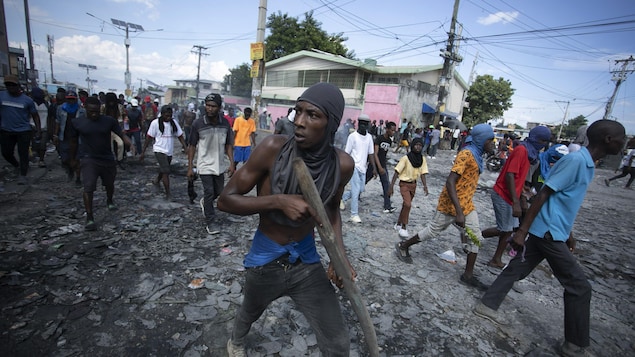 Des manifestants marchent dans une rue de Port-au-Prince.