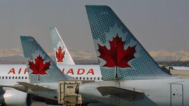 Des avions d'Air Canada stationnés près d'un aéroport.