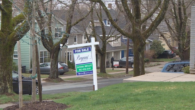 لافتة تفيد بأنّ منزلاً معروضٌ للبيع.
