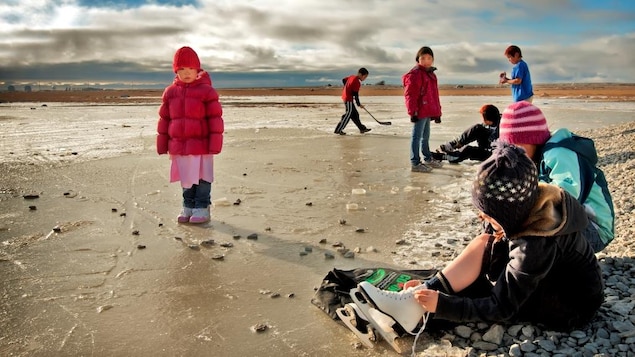 Enfants qui jouent sur la glace avec des patins Enfants qui jouent sur la glace avec des patins