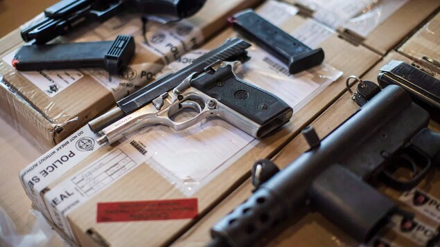 Guns seized during a series of raids by Toronto police are displayed for the media. The federal government plans to implement a permanent freeze on the importation of handguns into the country.
