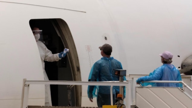 Des passagers sont contrôlés avant d'embarquer sur un avion.