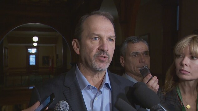 Harvey Bischof parle en entrevue dans un hall.