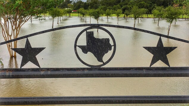 Un terrain clôturé au Texas est inondé à la suite du passage de l'ouragan Harvey.