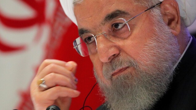 M. Rohani devant un drapeau iranien.