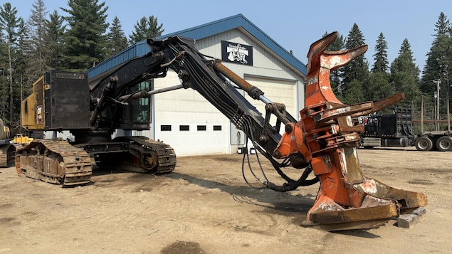 Une machine est à l'arrêt devant un garage.