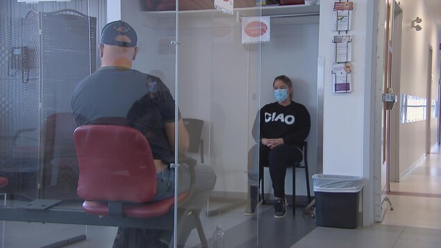 Deux personnes, un homme et une femme, assis dans une salle d'attente d'un cabinet médical.