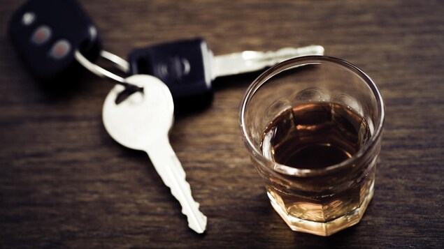 Des clés de voiture et un verre de whisky.