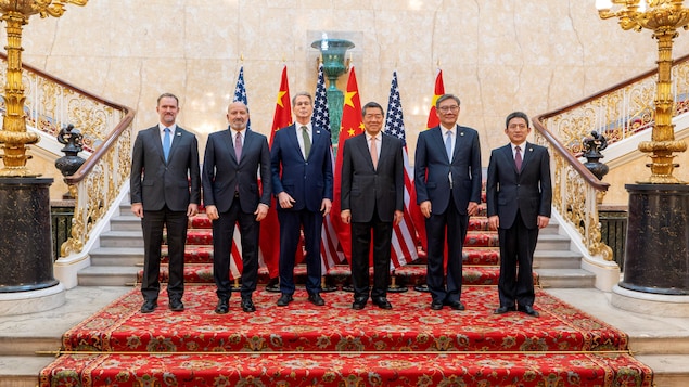 六個人站在中美兩國國旗前合照。