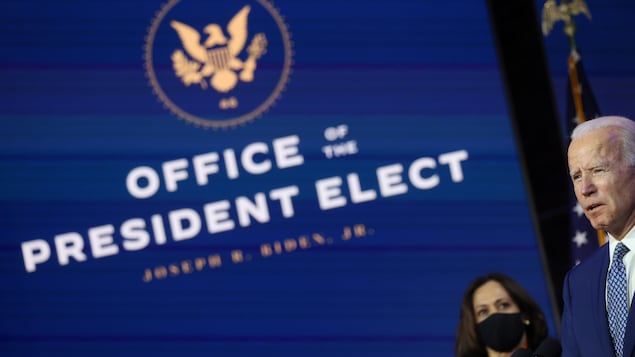 Kamala Harris observe Joe Biden.