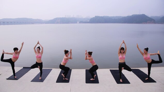 Des femmes font du yoga au bord de l'eau en Chine. Des femmes font du yoga au bord de l'eau en Chine.