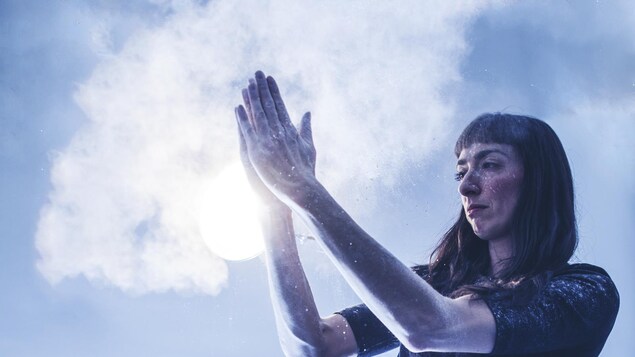 La danseuse Heather Cameron fait de la fumée en frappant ses mains remplies de talc.