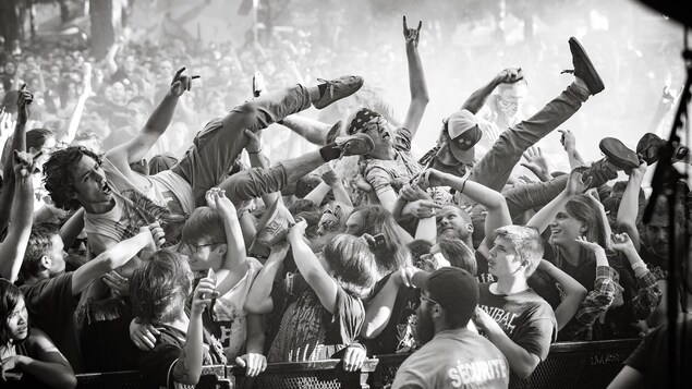 Des fans de métal surfent sur la foule au festival Heavy Montréal. Des fans de métal surfent sur la foule au festival Heavy Montréal.