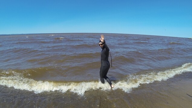 Heidi Levasseur marche dans l'eau du lac Saint-Jean vers le large.