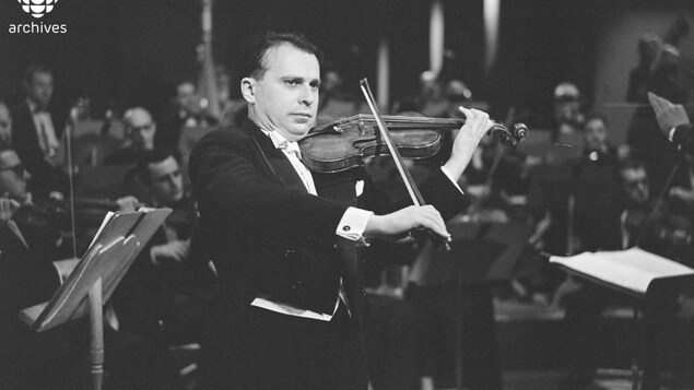 Henryk Szeryng jouant du violon devant un orchestre. Henryk Szeryng jouant du violon devant un orchestre.