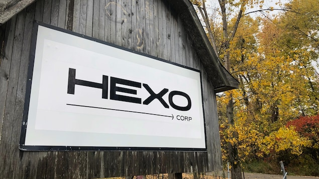 Un panneau extérieur en bois affiche le nom de l'entreprise à l'entrée