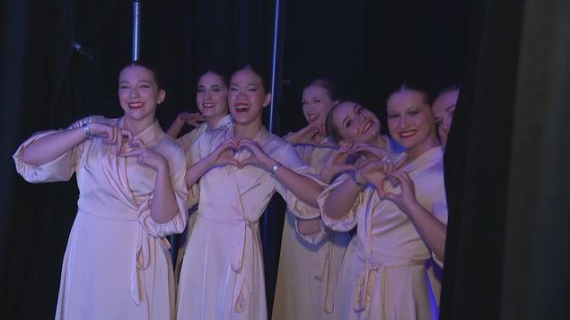 Des danseuses attendent en coulisses vêtues de peignoirs.