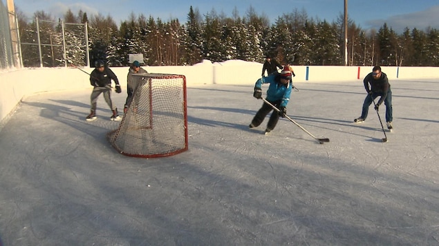 Les patineurs s'adonnent à du hockey de participation sur une patinoire extérieure de Sept-Îles