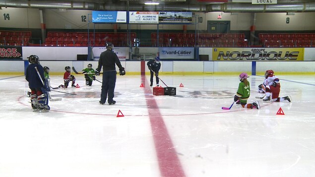 De jeunes joueurs de hockey s'exercent sur la glace.