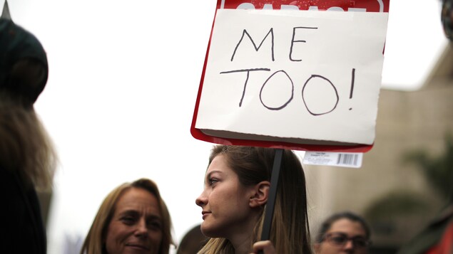 Une jeune femme brandit une pancarte