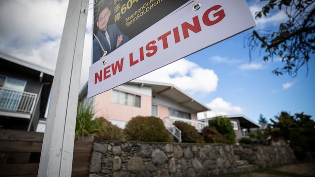 Isang detached na bahay na may nakapaskil na sign sa harap na nagsasabing new listing.
