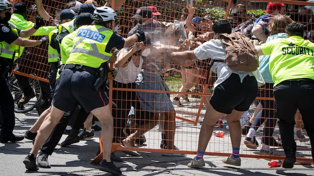 Gamit ang bakod na gawa sa metal, hinarangan ng mga tao ang mga pulis.
