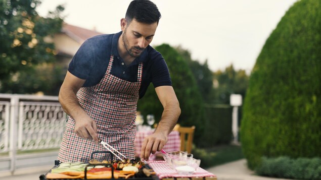 Un homme prépare un barbecue à l'extérieur. Un homme prépare un barbecue à l'extérieur.