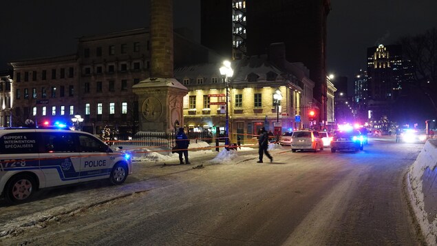 Des policiers du SPVM établissent un périmètre de sécurité sur la place Jacques-Cartier. 