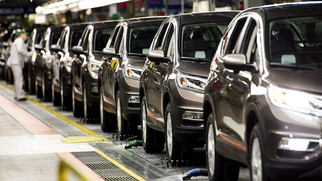 Un travailleur inspecte les véhicules à l'usine de Honda.