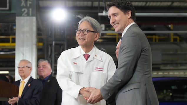 Nagkamay sina Justin Trudeau at Toshihiro Mibe sa loob ng planta ng mga sasakyan.