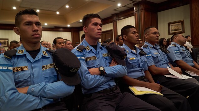 Des policiers assis dans une salle, au Honduras. Des policiers assis dans une salle, au Honduras.