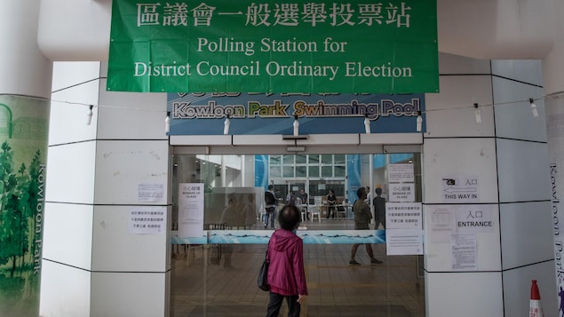 Une femme passe devant un bureau de vote à Hong Kong.