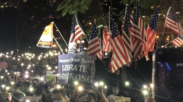 Des manifestants réunis le soir avec des bougies et des drapeaux américains.