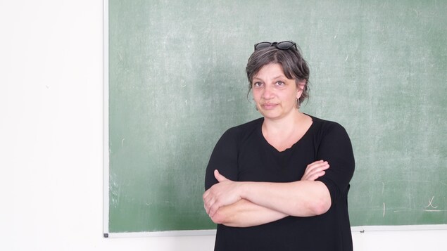 Une femme devant un tableau, dans une classe