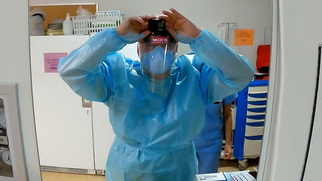 Le Dr Patrick Bellemare se regarde dans le miroir afin de s'assurer que sa caméra enregistre.